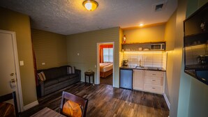 A compact living space with a kitchenette, a dining area, and a bedroom.