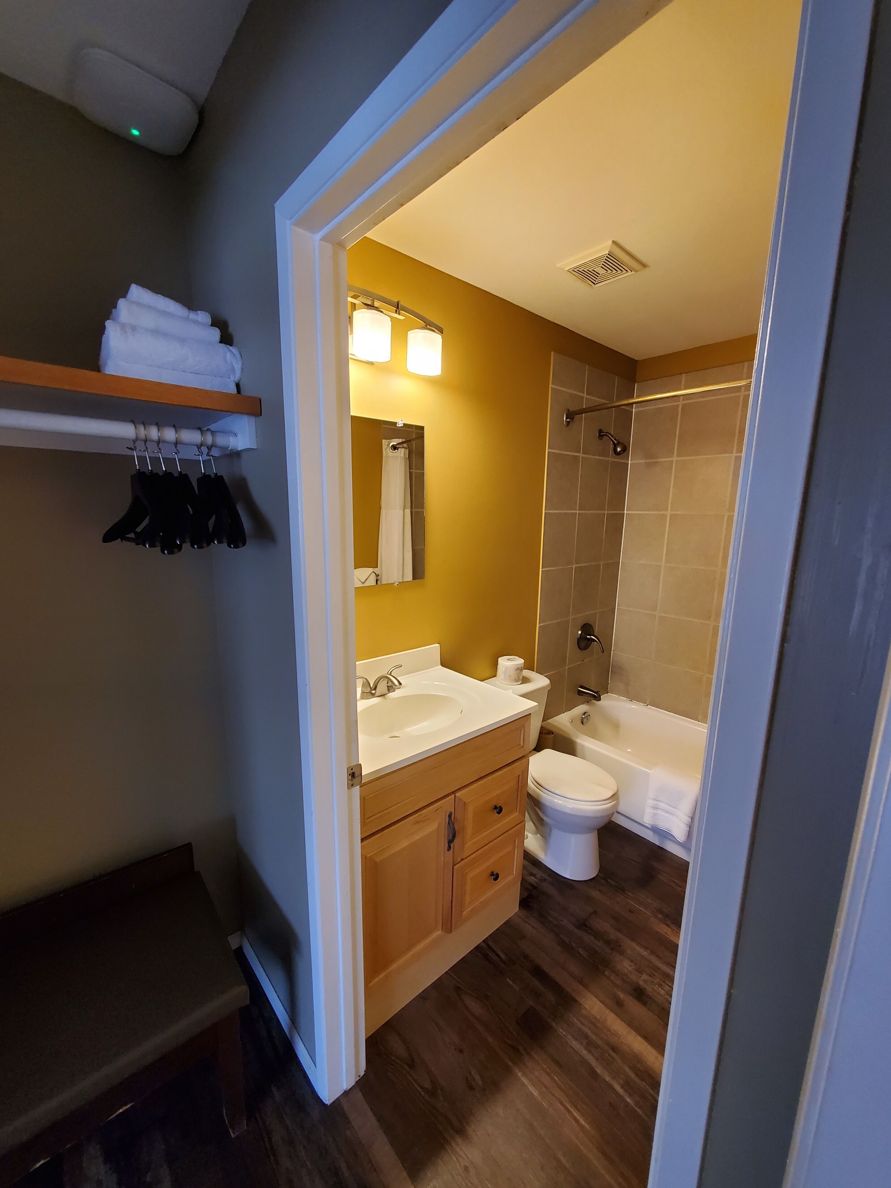 Une salle de bain moderne avec un meuble-lavabo en bois, des toilettes, un lavabo et une douche.