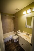 A bathroom with a bathtub, toilet, and sink.