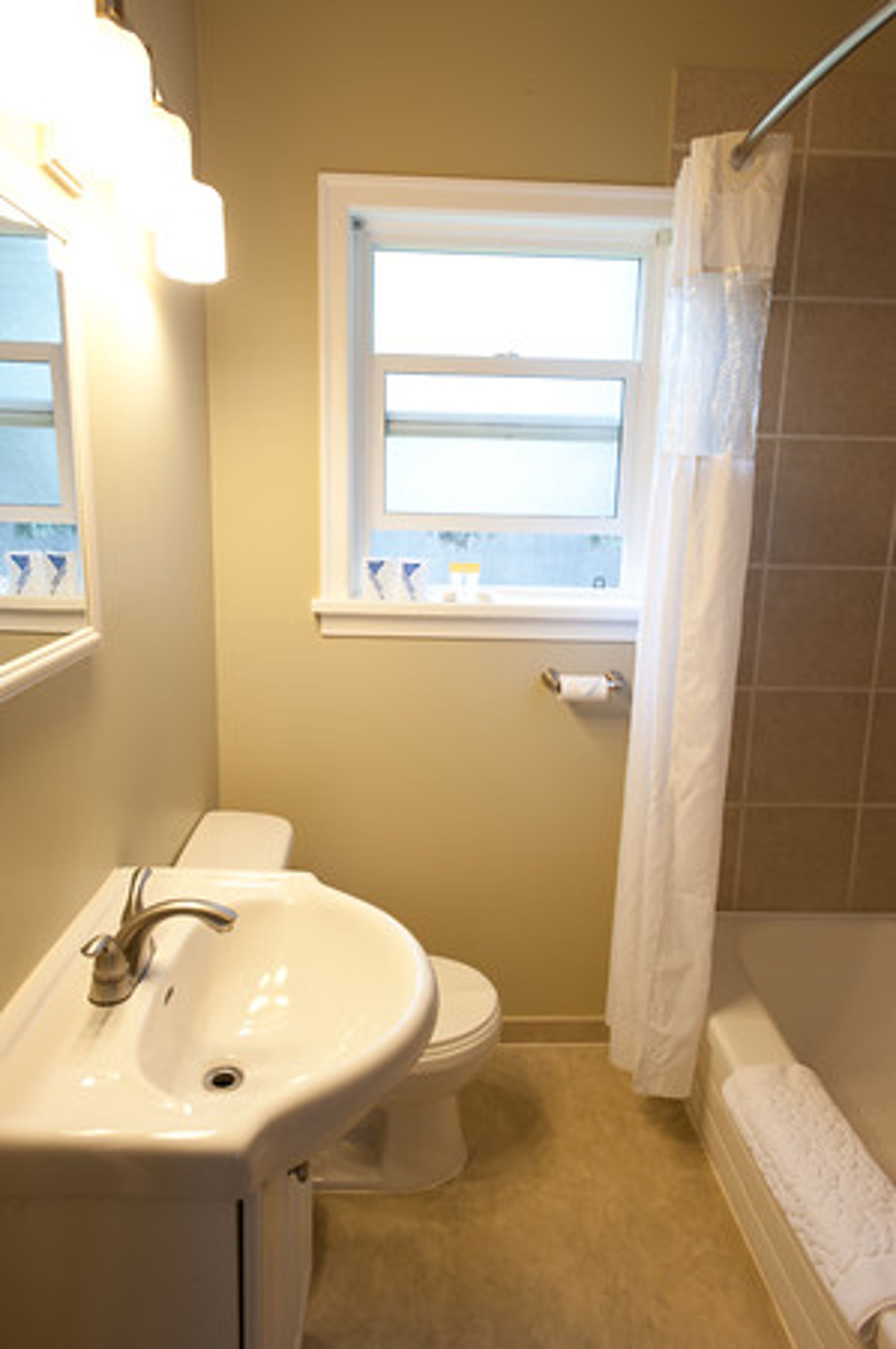 Un baño con lavamanos, inodoro y bañera.
