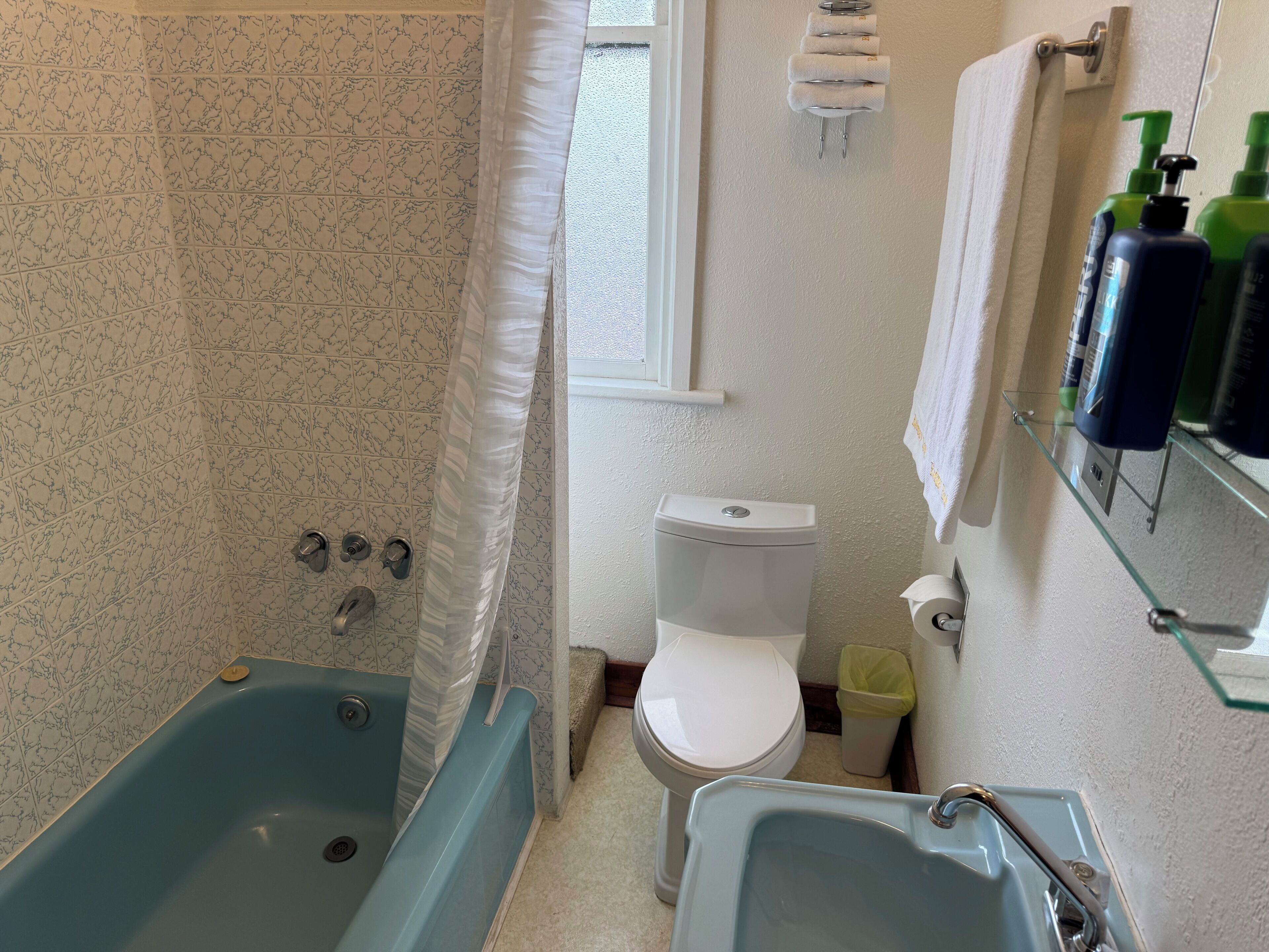 Un baño con bañera, inodoro y lavamanos.