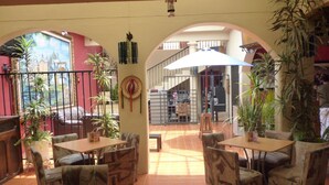 An indoor patio area with tables and chairs, surrounded by arches and potted plants. - Hotel Casa Madero (San Cristóbal de las Casas)