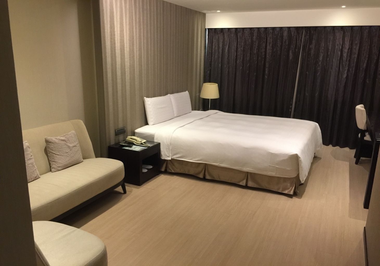 Une chambre d’hôtel comprenant un lit, un canapé, une table de chevet avec une lampe et une chaise.
