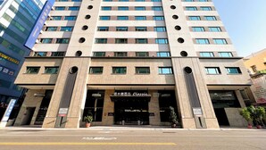 Un hotel de varios pisos con una entrada destacada, amplias ventanas y un diseño arquitectónico moderno.