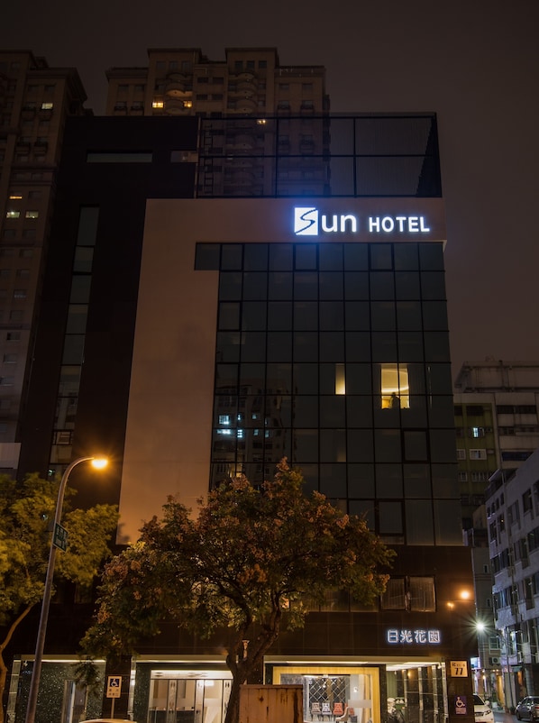 A modern hotel building with a prominent 'Sun Hotel' sign, large windows, and a visible entrance.