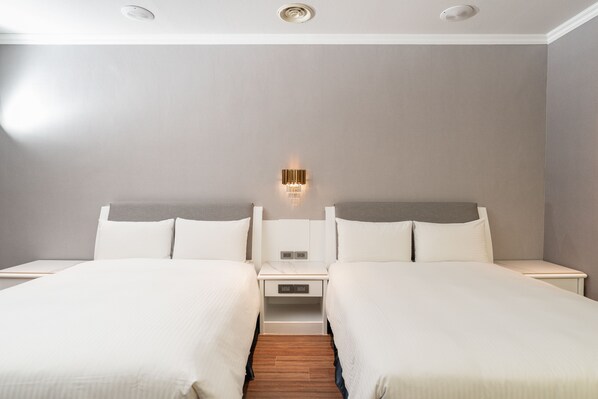 A hotel room with two beds, a nightstand, a wall-mounted light, and a ceiling vent. - Yilan Fu Hsiang Hotel (Yilan)
