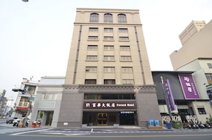Un hotel alto con fachada moderna, múltiples ventanas y una entrada destacada.