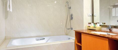 A modern bathroom with a bathtub, a sink, and a vanity.
