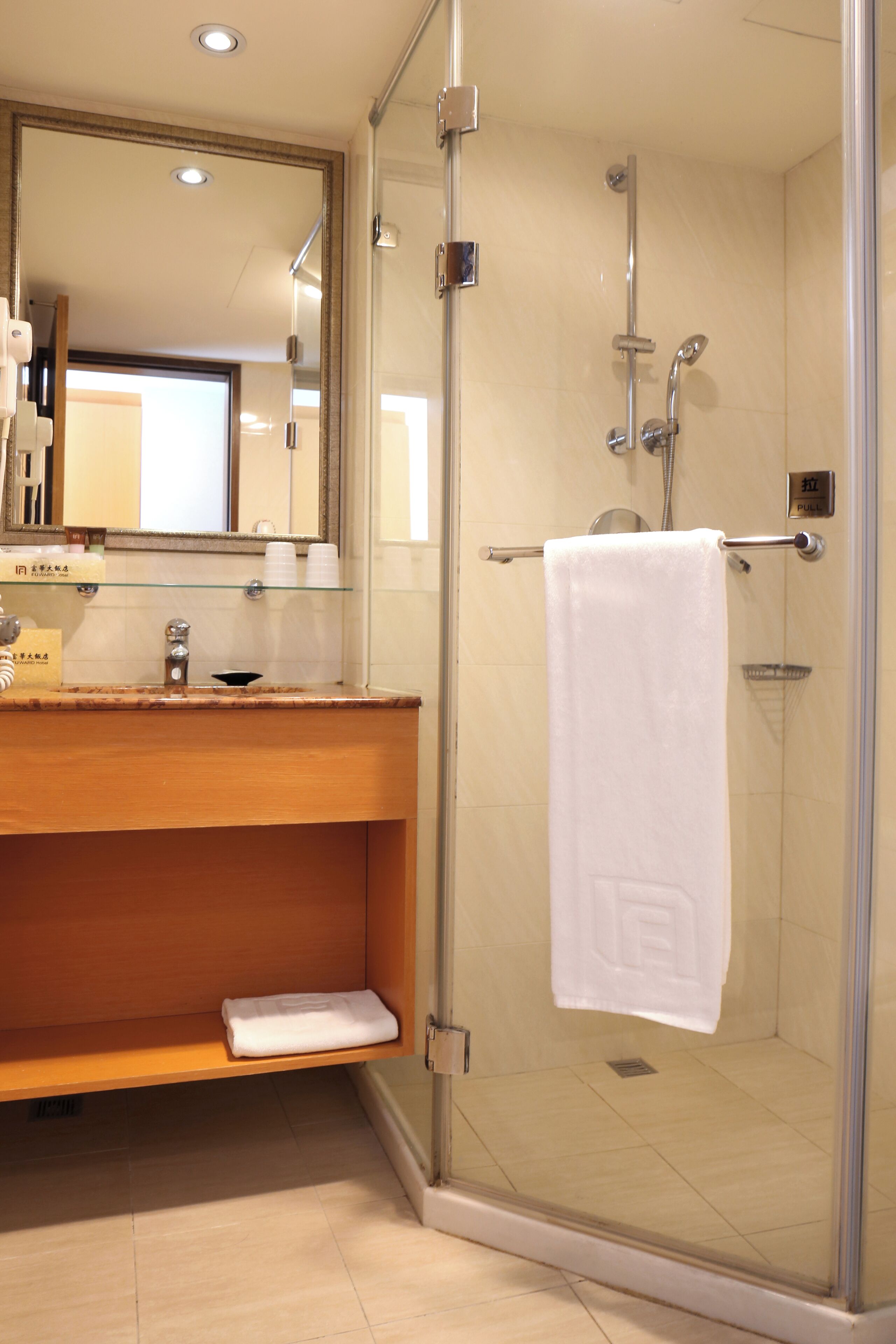 Une salle de bain moderne avec une douche à parois de verre, un meuble-lavabo en bois et un grand miroir.