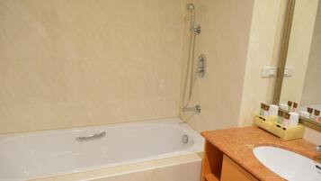 A bathroom with a bathtub, a sink, and a mirror.