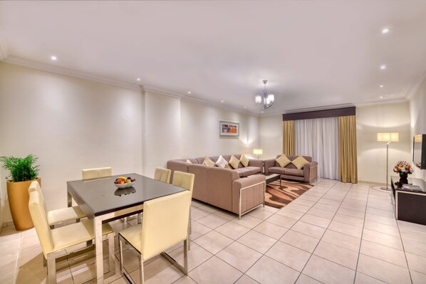 A modern living room with a dining area, a sofa set, and a flat-screen TV. - Pearl Marina Hotel Apartments (Dubai)