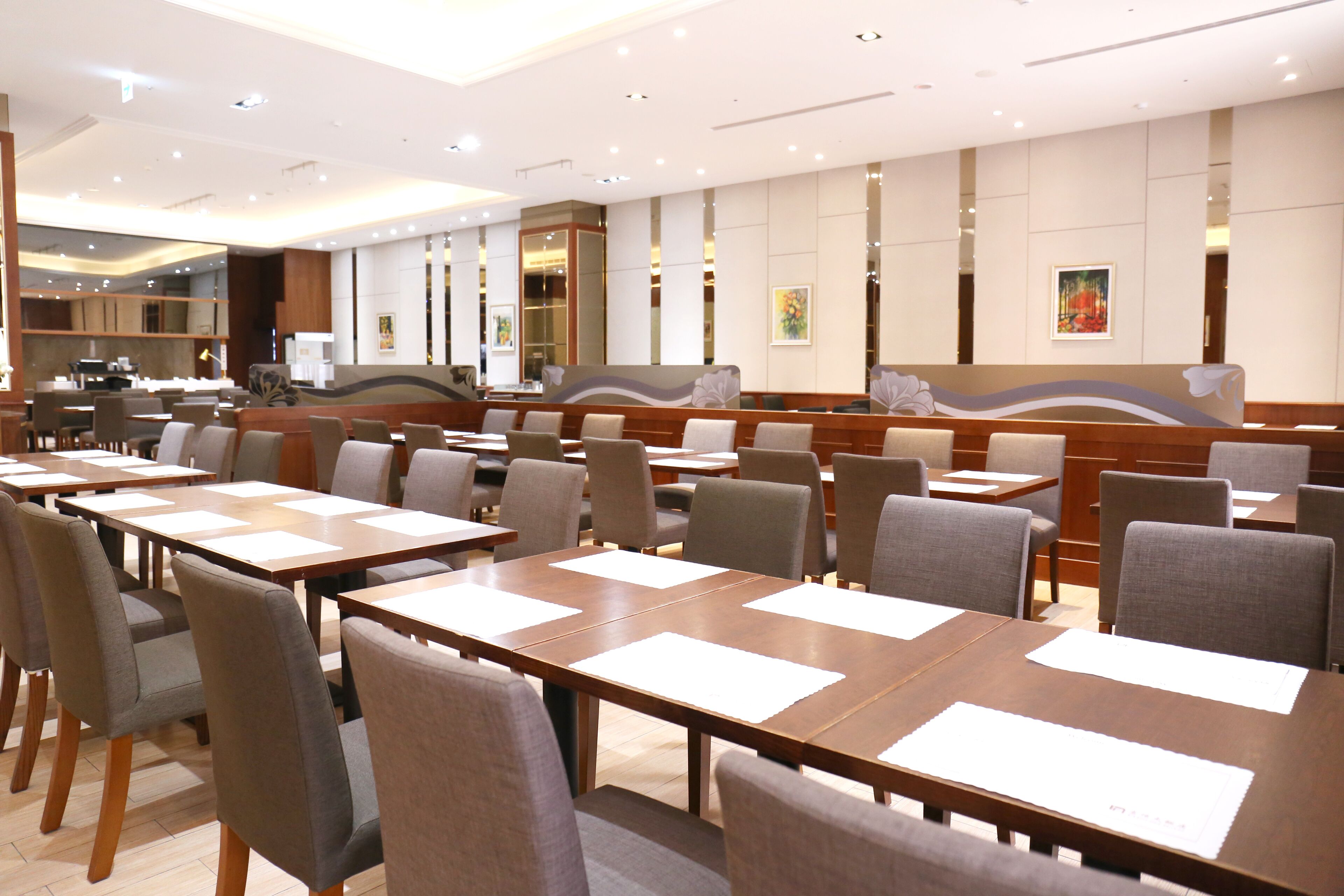 A conference room with multiple tables and chairs, equipped with nameplates and a modern design.