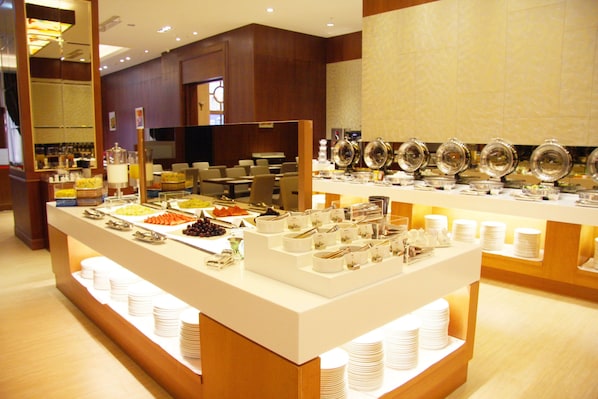 A buffet setup with various food items and utensils.