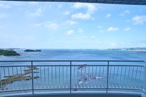 Un balcón con vista al mar y a la costa lejana.