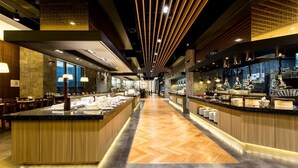 Un hall d’hôtel moderne doté d’un bar central, d’un revêtement de sol en bois et d’un long comptoir offrant divers services.