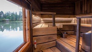 A wooden cabin with a bench and a metal bucket. - Majatalo Onnela (Tuusula)