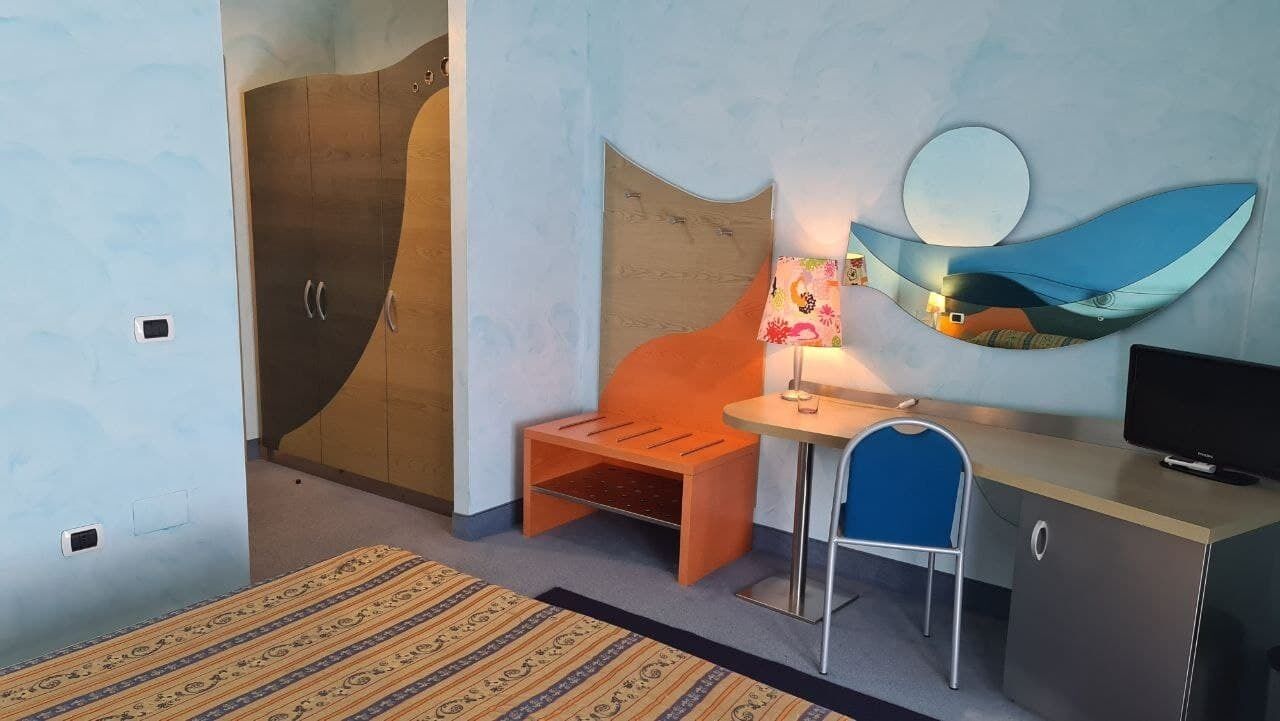 Una habitación moderna con escritorio, silla y cama.