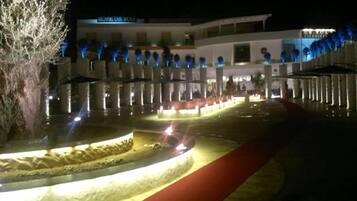Ein Hotel mit Innenhof, rotem Teppich und blauen Lichterketten.