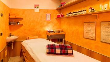 Ein Wellnessraum mit einem Bett, einem Waschbecken, Regalen mit Toilettenartikeln und Zertifikaten an der Wand.