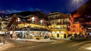 A hotel with multiple balconies and a well-lit entrance. - Leading Relax Hotel Maria (Moena)