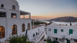 Un bâtiment blanc doté de fenêtres en arc de cercle et d’un balcon offrant une vue sur la côte.
