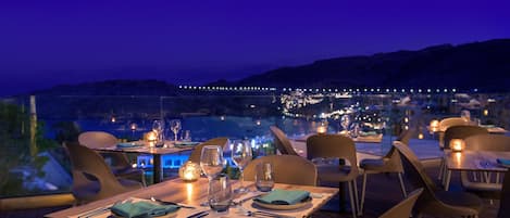 A restaurant with tables set for dining, overlooking a scenic view.