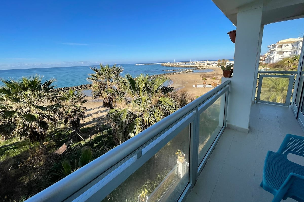 A balcony with a view of a beach and ocean.
