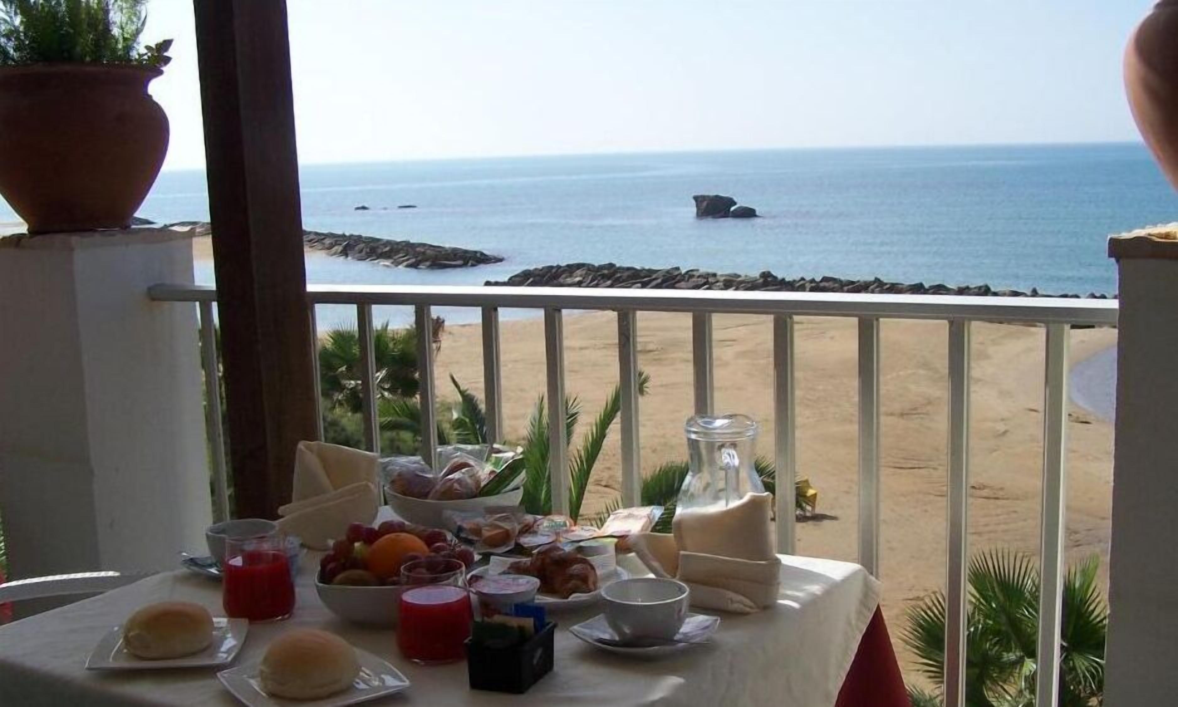 Uma mesa de café da manhã com vista para a praia e o oceano.