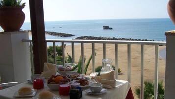 Uma mesa de café da manhã com vista para a praia e o oceano.
