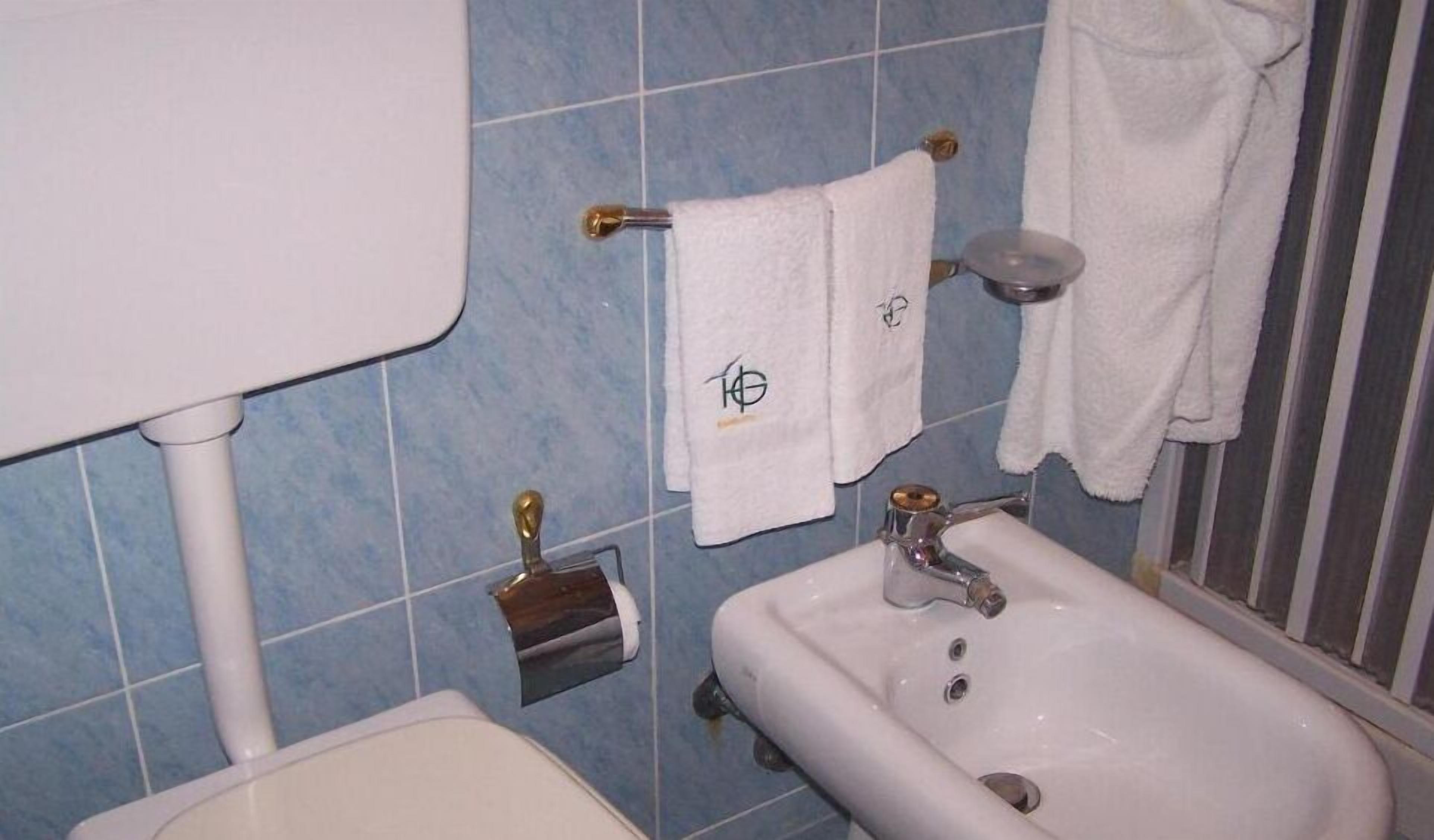 Ein Badezimmer mit Waschbecken, Spiegel und blauen Fliesen.