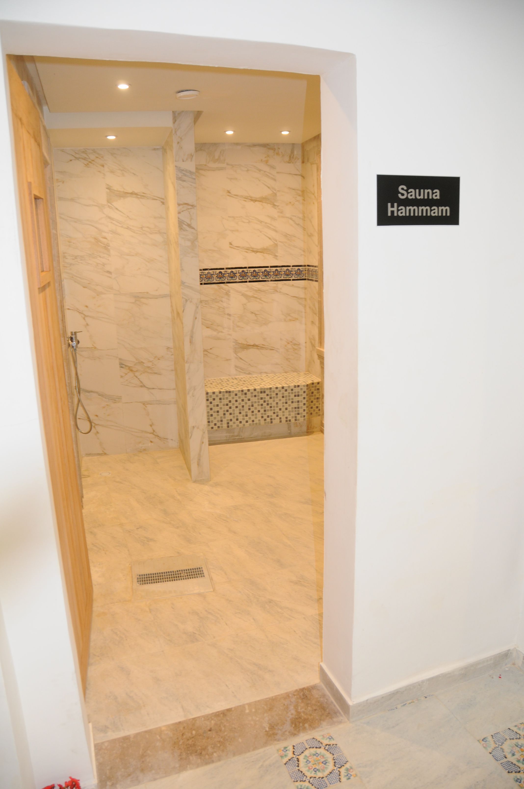 Una sauna con paredes de mármol y suelo de baldosas.