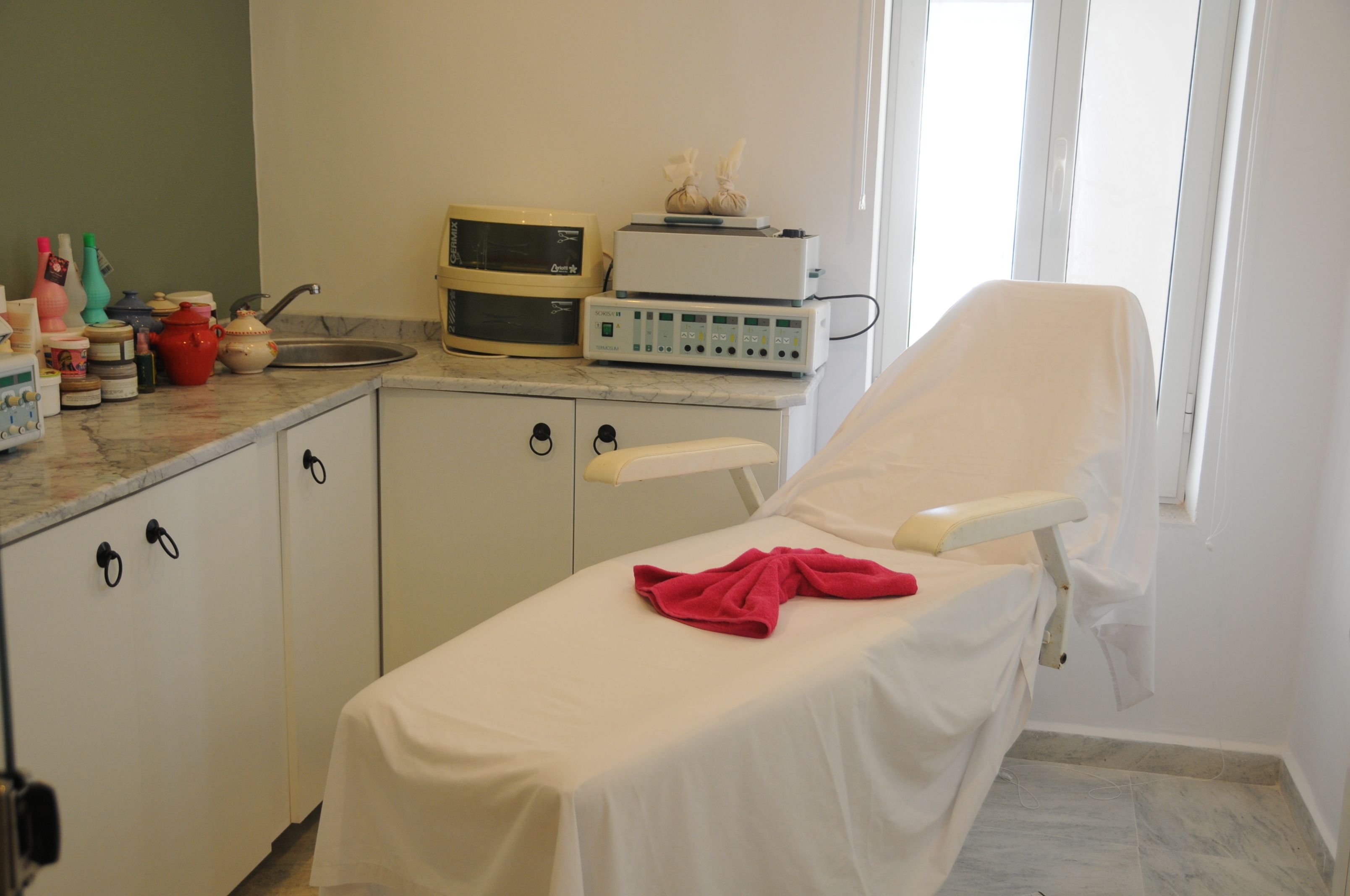Un consultorio médico con una cama, equipo médico y armarios.