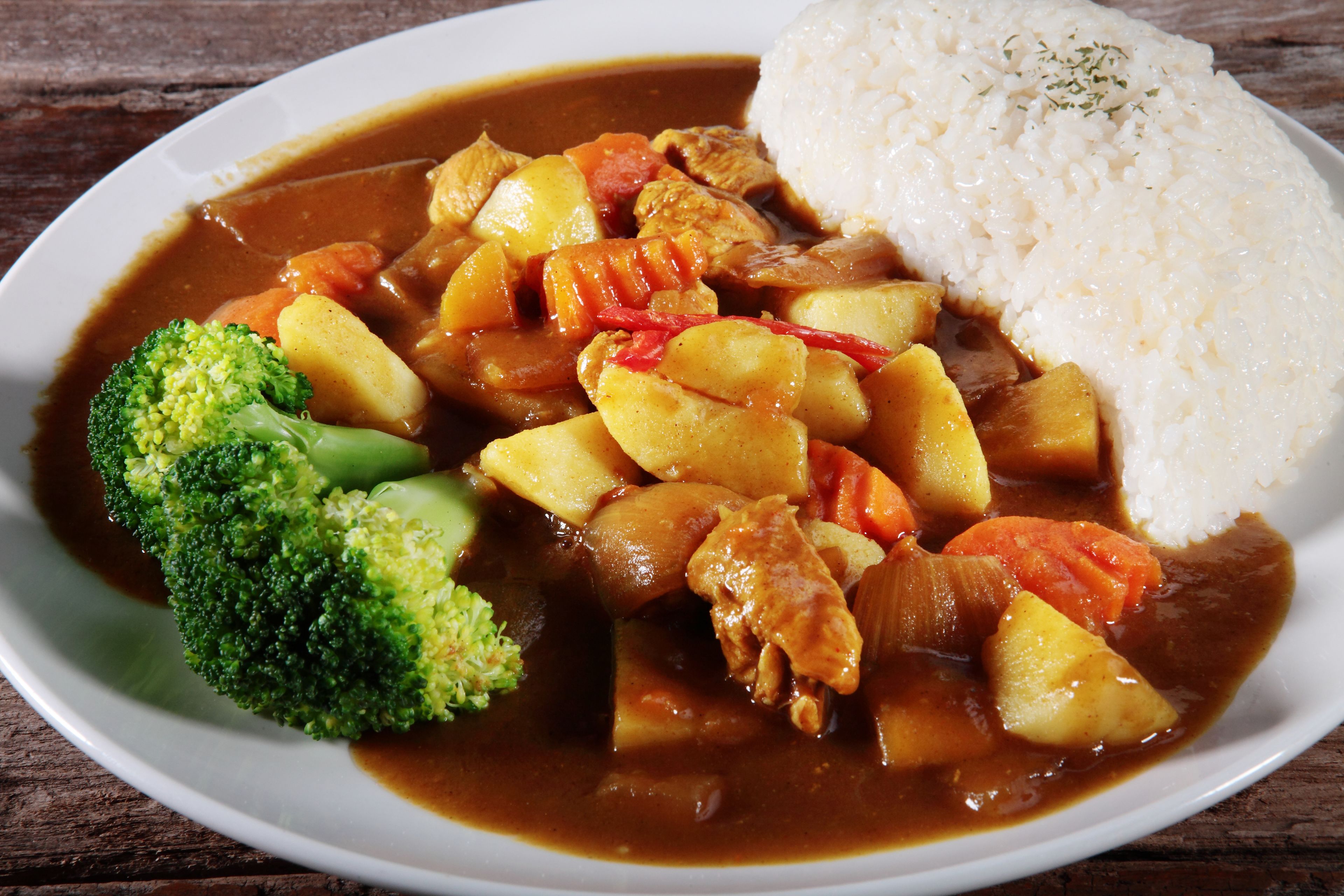 A plate of food with rice, chicken, potatoes, and broccoli.