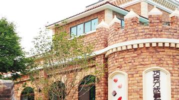 A brick building with a turret and arched windows, featuring a sign with Chinese characters.