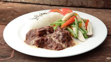 Une assiette de nourriture composée de riz, de viande et de légumes.