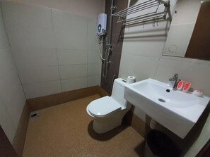 A bathroom with a toilet, a sink, a shower, and a towel rack. - Bangi Gateway Hotel (Bandar Baru Bangi)