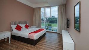 A bedroom with a large bed, a nightstand, a TV, and a view of the outdoors. - Bangi Gateway Hotel (Bandar Baru Bangi)