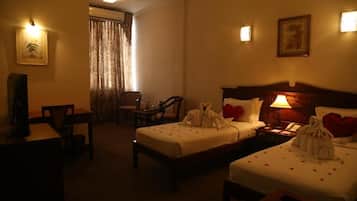 Une chambre d’hôtel avec deux lits, un bureau, une chaise et un téléviseur.