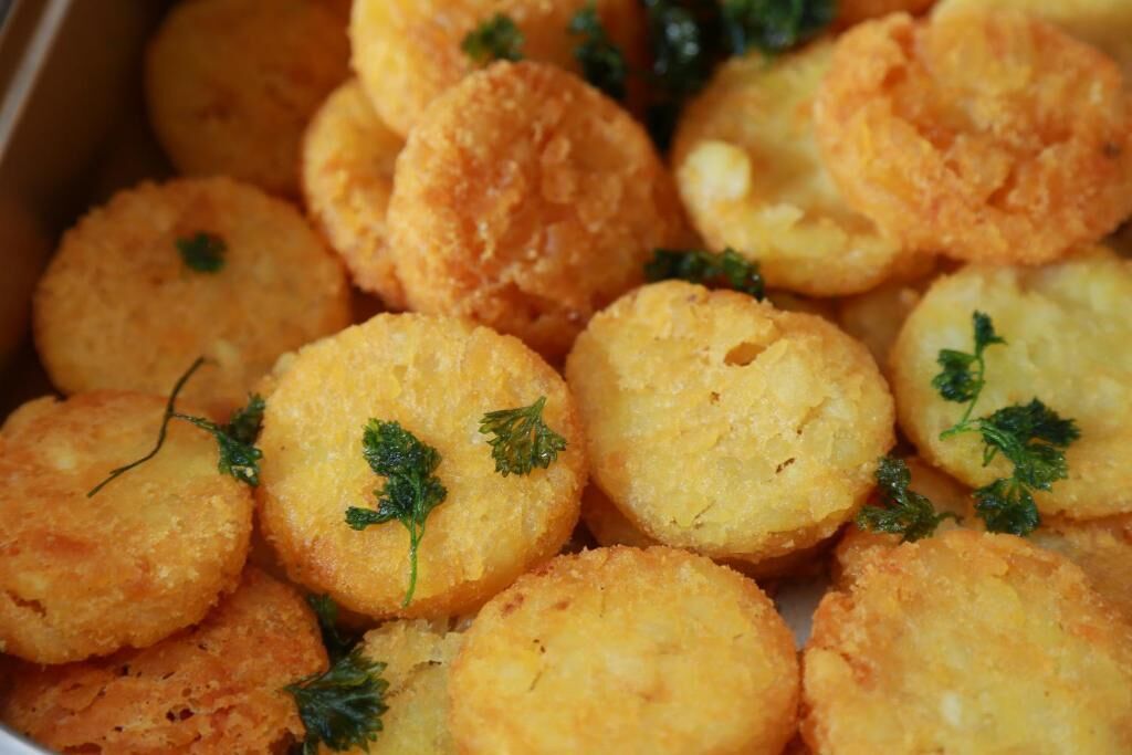 Une assiette de mets frits, dorés et croustillants, décorée d’herbes fraîches.