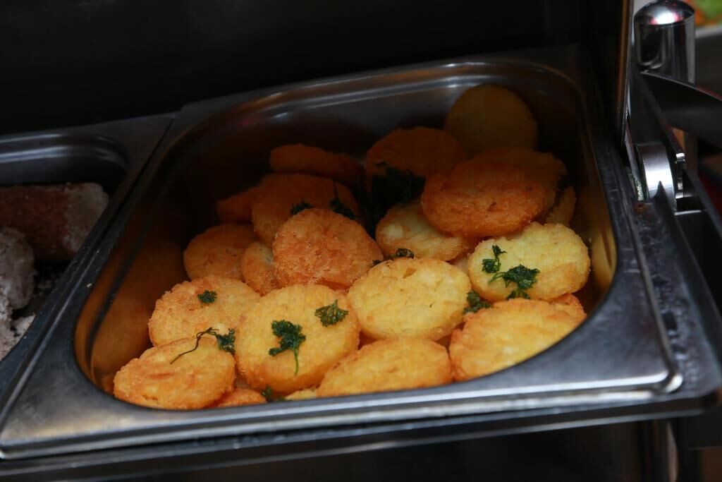 A buffet with various food items including bread and potato wedges.