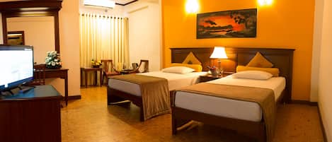 A hotel room with two beds, a television, a desk, and a painting on the wall.