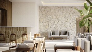 A modern living room with a stone wall, a sofa, and a large plant. - Hotel Labineca (Gradac)