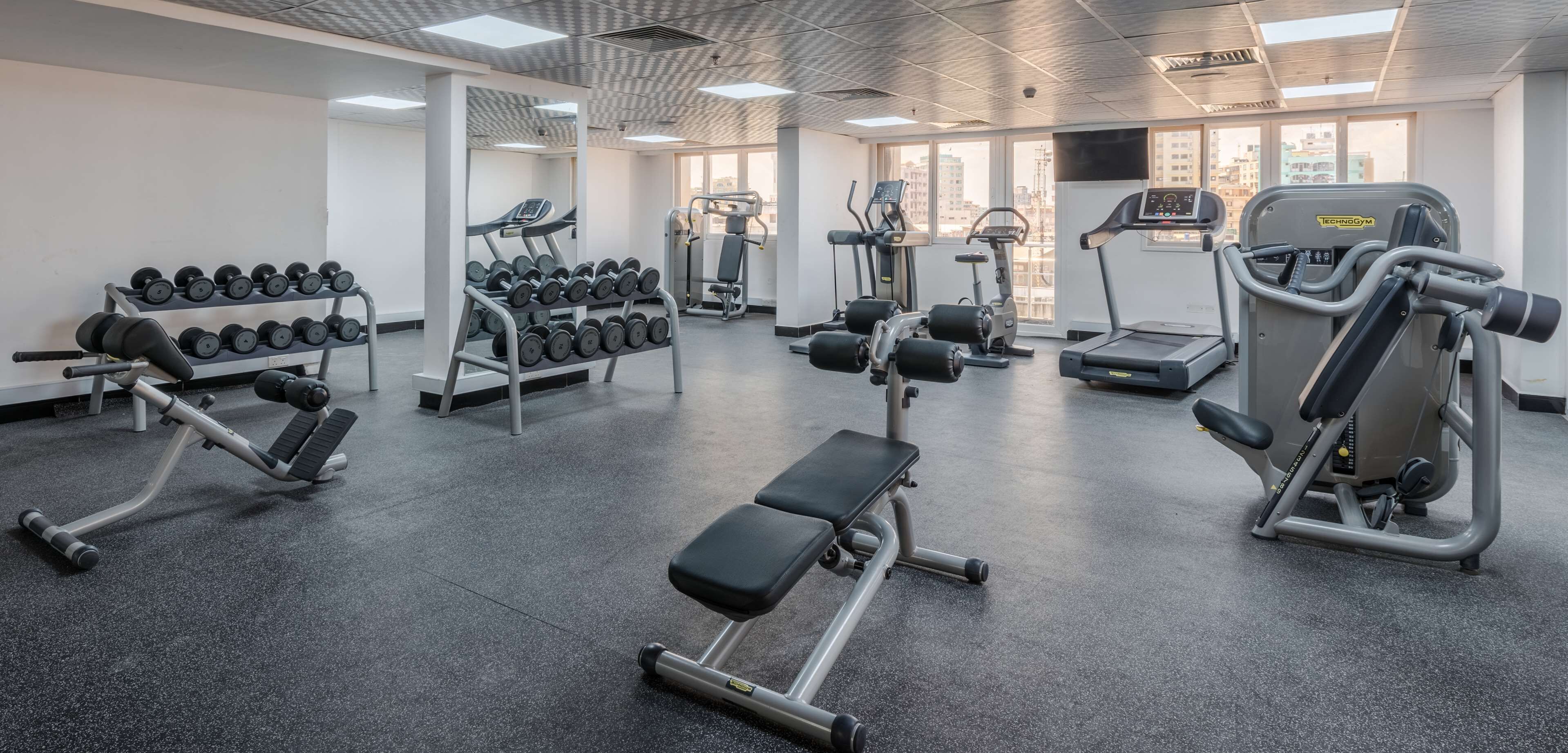 Een moderne sportschool met diverse apparaten, waaronder gewichten, loopbanden en krachttoestellen.
