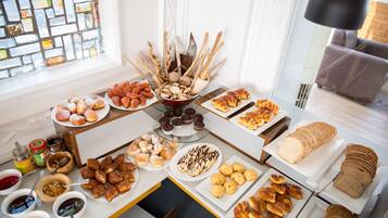 A buffet table with various baked goods and pastries.