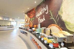 A buffet area with a variety of food options and a mural depicting fresh produce. - HARRIS Hotel & Conventions Ciumbuleuit Bandung (Bandung)