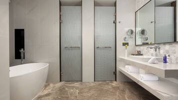A modern bathroom with a freestanding bathtub, a vanity with a mirror, and a shower enclosure.