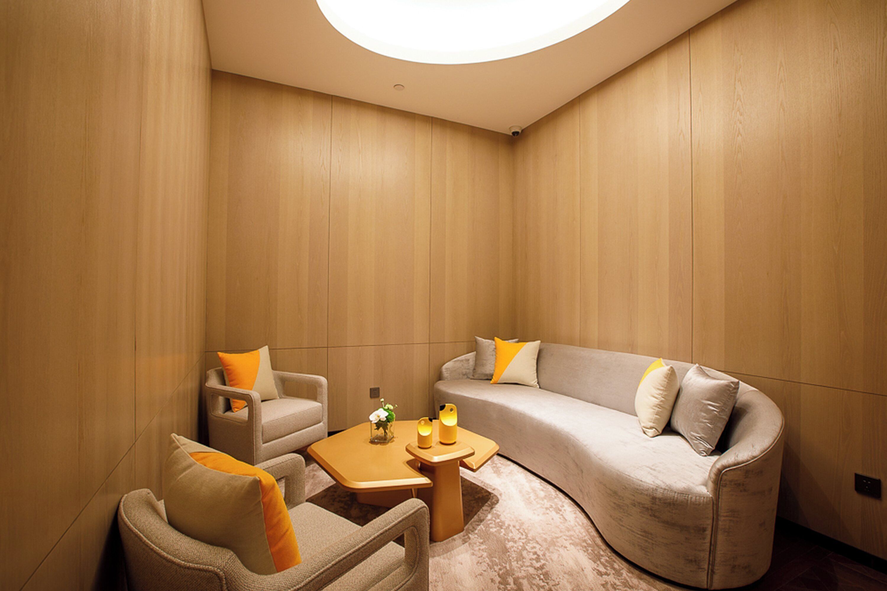 A modern living room with a curved sofa, armchairs, and a small coffee table.