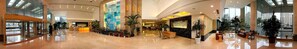 Welcome to our hotel lobby, featuring a reception area, decorative wall, and lush greenery.