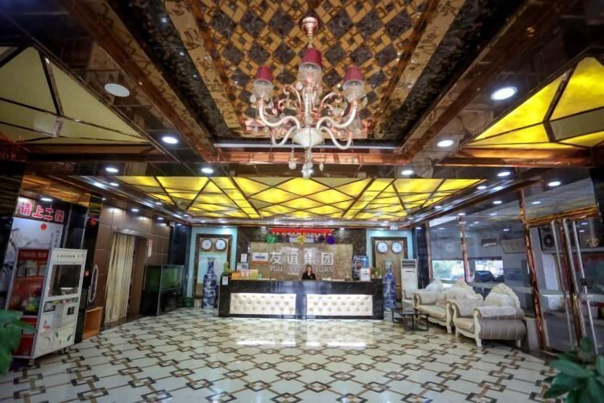A lobby with a patterned floor, a reception desk, and a chandelier.
