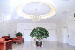 A lobby with a chandelier, a reception desk, and a potted plant. - Jinyuwan Hotel (Dalian Lvshun University Town) (Dalian)